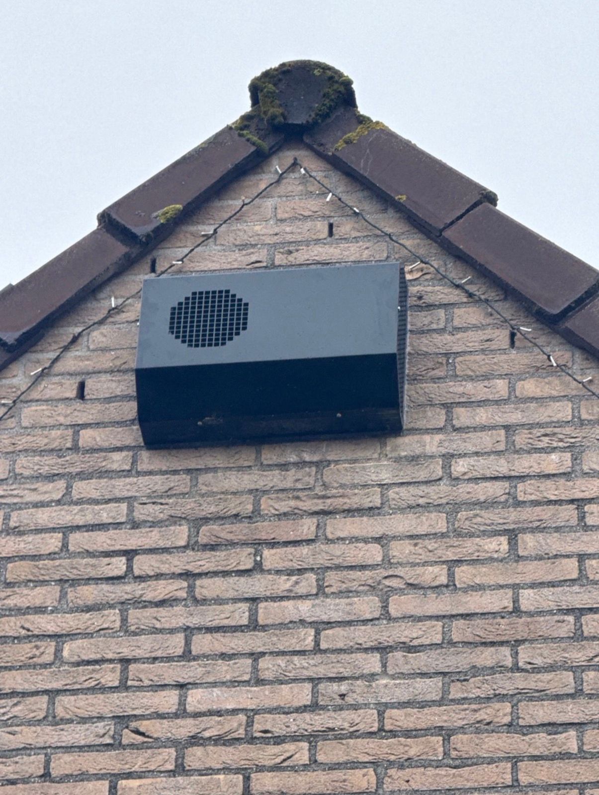 Ventilatie-unit aan de gevel onder de nok